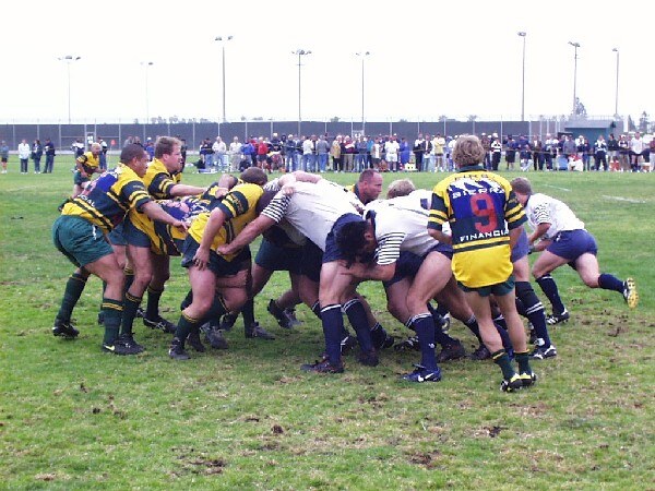 An OMBAC scrum engages against a gold and blue side