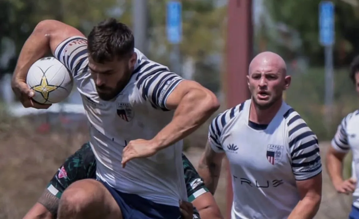 OMBAC player carrying the ball with a teammate in support